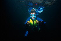 Boy (nine years) free diver holding green crabs, Plum Cove, Gloucester, Massachusetts, USA Model released Model released.