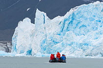 Zodiac boat with travellers in front of the Monaco Glacier, Leifdefjord, Svalbard, Norway 2010