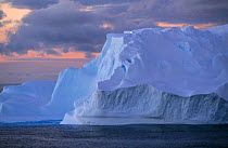 Iceberg in alpenglow after sunset with cloudy sky behind, Antarctica, 1998.