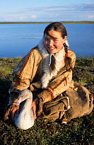 Nenets girl posing with pet Bewick's swan cygnet (Cygnus columbianus bewicki) at summer camp near Nadym, Yamal, Western Siberia, Russia, 2000.
