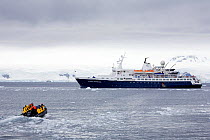 Zodiac full of tourists returning to the "Clipper Adventurer" from a landing on Trinity Island, Antarctica, February 2009.