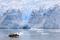 Zodiac full of passengers passing a glacier in Cierva Cove, Antarctica, February 2009.