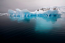 Low flat iceberg with deep keel visible underwater, Whittle Peninsula, Antarctica, 2009.