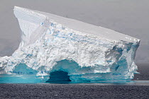 Tilted tabular iceberg with an ice cave, Antarctica, 2009.