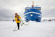 Passenger from the "Ocean Nova" pretending to tug the boat at Deception Island. South Shetland Islands, Antarctica, 2009.