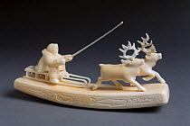 Ivory carving of Chukchi driving a reindeer sled. Chukotka, Siberia, Russia.
