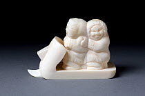 Ivory carving of native Siberian couple riding on a snowmobile. Tobolsk, Siberia, Russia.
