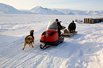 Yupik Eskimo hunters travelling by snowmobile in New Chaplino village. Chukotskiy Peninsula, Chukotka, Siberia, Russia, 2010