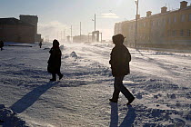 People walking along Dezhnova Street on a stormy day in Lavrentiya. Chukotskiy Peninsula, Chukotka, Siberia, Russia, 2010