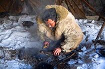 Chukchi herder preparing to make fire with traditional fire making device during ritual. Chukotskiy Peninsula, Chukotka, Siberia, Russia, spring 2010