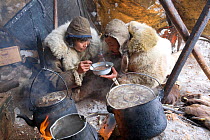Chukchi reindeer herders sharing a bowl of hot reindeer stew. Chukotskiy Peninsula, Chukotka, Siberia, Russia, spring 2010