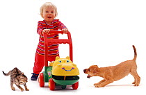 Young girl with hippo walker, kitten and puppy. Model released