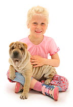 Portrait of young blonde haired girl sitting with a Shar-pei puppy Model released