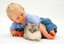 Portrait of toddler playing with Bengal cat. Model released