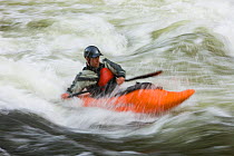 A kayaker plays in a hole in Tariffville Gorge on the Farmington River in Tariffville, Connecticut. Class III whitewater. May 2007. Model released.