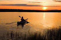 Woman kayaking at sunset in the Connecticut River in Old Lyme, Long Island Sound, Connecticut, USA, August 2006