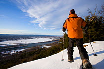 Man snowshoeing on the Metacomet-Monadnock Trail, Mount Holyoke, Skinner State Park, above the Connecticut River Valley, Hadley, Massachusetts, USA, model released, March 2007