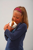 Girl cuddling a Guinea Pig