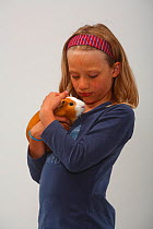 Girl cuddling a Guinea Pig