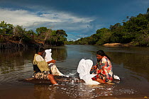 Amerindian women doing their laundry in the Rupununi River, Karanambu Lodge, Rupununi, Guyana, February 2010