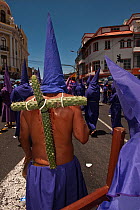 Cucuruchos carrying a cross made from prickly cactus, during the Good Friday Procession commemorating the Passion and Death of Jesus Christ, Quito, Ecuador, April 2010