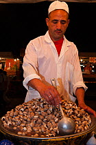Market vendor selling Snails for food, Djemaa el-Fna (the square), Marrakech, Morocco, June 2009