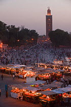 Food stalls in the market at night with Koutoubia Mosque in the background, Djemaa el-Fna (the square), Marrakech, Morocco, June 2009