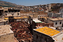 Traditional leather tanneries with leather pelts drying on roof in the sun, and the dyeing vats, Fes, Morocco, June 2009