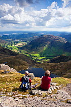 Couple looking out over Stickle Tarn and Great Langdale valley, from Pavey Ark. Lake District, Cumbria, England. September 2010.