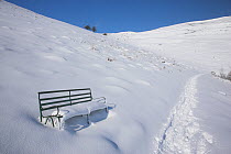Snow covered bench by a footpath in the Malvern Hills. Worcester, UK, February 2010.