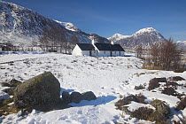 Black Rock Cottage with snow-covered Buachaille Etive Mor in the distance. Rannoch Moor, Glen Coe, Scotland, March 2010.