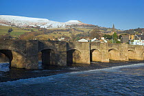 The 17th century bridge at Crickhowell, Powys, with snow covered hills beyond. Brecon Beacons National Park, Wales, January 2010.
