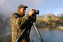 Igor Shpilenok photographing in Valley of the geysers, Kamchatka, Far East Russia, June 2007, photograph by Dmitry Shpilenok