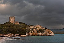 Figari bay and medieval watchtower, with dark storm clouds, Southern coast of Corsica island, Bonifacio, France, Febraury 2010