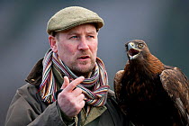 Golden Eagle (Aquila chrysaetos) with falconer Andy Hughes. Glenfeshie, Scotland, February.