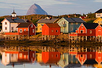 The fishing village of Lovund, with the top of Tomskjevelen (Tomma island) in the background, Luroy, Helgeland, Nordland, Norway, July 2009