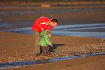 Father and son looking at Severn estuary intertidal zone,Gloucestershire,England,UK, December 2009. MRDELETE