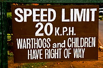 Speed limit sign, stating that Warthogs and children have the right of way, Nairobi National Park, Kenya, April 2007