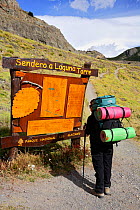 Hiker studies map on signpost at the beginning of the Laguna Tower trail, El Chalten, Los Glaciares National Park, Patagonia, Argentina, January 2006