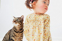 Portrait of young girl with short-haired tabby cat