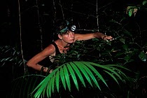 Photographer, Catherine Jouan, searching for nocturnal animals in rainforest, Borneo, Sarawak, Malaysia. Model released