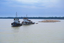 Log rafts being pulled by boats on Rejang river, Borneo, Sarawak, Malaysia