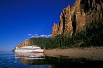 Cruise ship anchored in River Lena off Kembrian stony poles and towers, LenskieStolby nature reserve, Yakutia-Sakha, East Siberia, Russia, August 2005