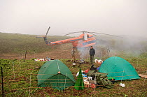 Photographer Sergey Gorshkov's camp with tents and helicopter, surrounded by fence for protection against bears, Kamchatka, Far east Russia, July 2005