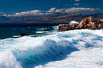 Waves breaking onto rocky shore on the northeast coast of Corfu, with the Albanian coast beyond. Corfu, Greece, June 2010.