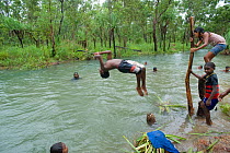 Aboriginal children from Napranum Aboriginal Community somersaulting in the flooded creek. Queensland, Australia, February 2008