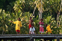 Young West Papuan kids fishing from the their village jetty. Raja Ampat, West Papua, Indonesia, February 2010