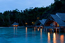 Bungalows of Misool Eco Resort as night falls. Misool, Raja Ampat, West Papua, Indonesia, January 2010