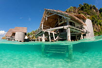 Split level showing sandy seabed in front of the bungalows of Misool Eco Resort. Misool, Raja Ampat, West Papua, Indonesia, January 2010.