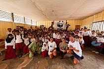 Students from Yellu Village posing with photographers Jurgen and Stella Freund  and Misool Eco Resort staff in front of the WWF panda flag. Misool, Raja Ampat, West Papua, Indonesia, January 2010.